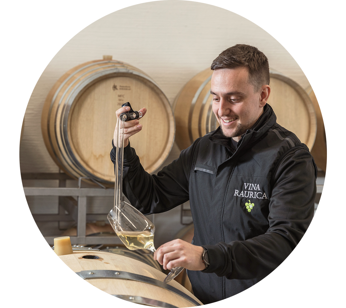 Ein Mitarbeiter überprüft einen Wein im Fasskeller.